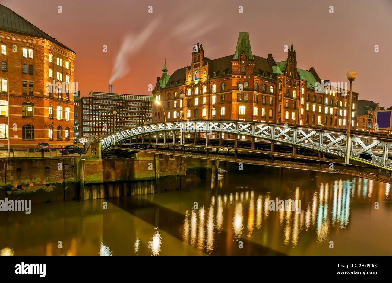 The night walk in Speicherstadt district observing scenic historical warehouses, the multi-storey buildings standing at the canals, Hamburg, Germany Stock Photo