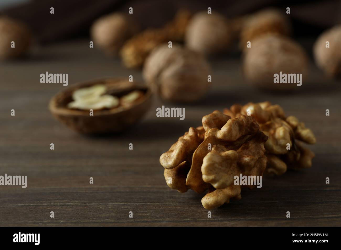Walnuts with kitchen towel on wooden background Stock Photo