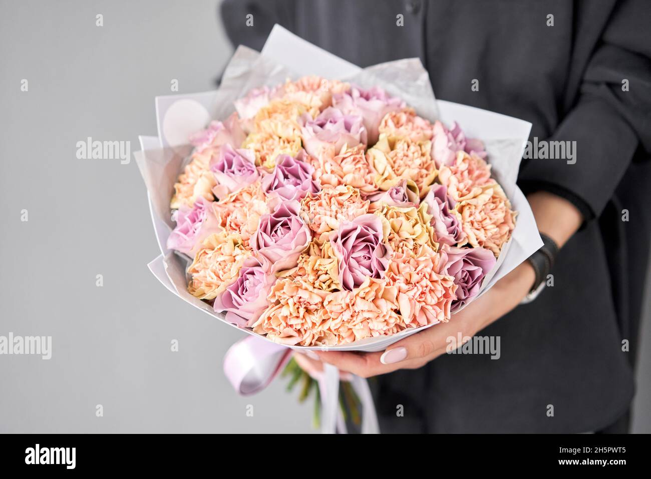 Large Beautiful bouquet of mixed flowers in woman hand. Floral shop concept . Beautiful fresh cut bouquet. Flowers delivery. Stock Photo