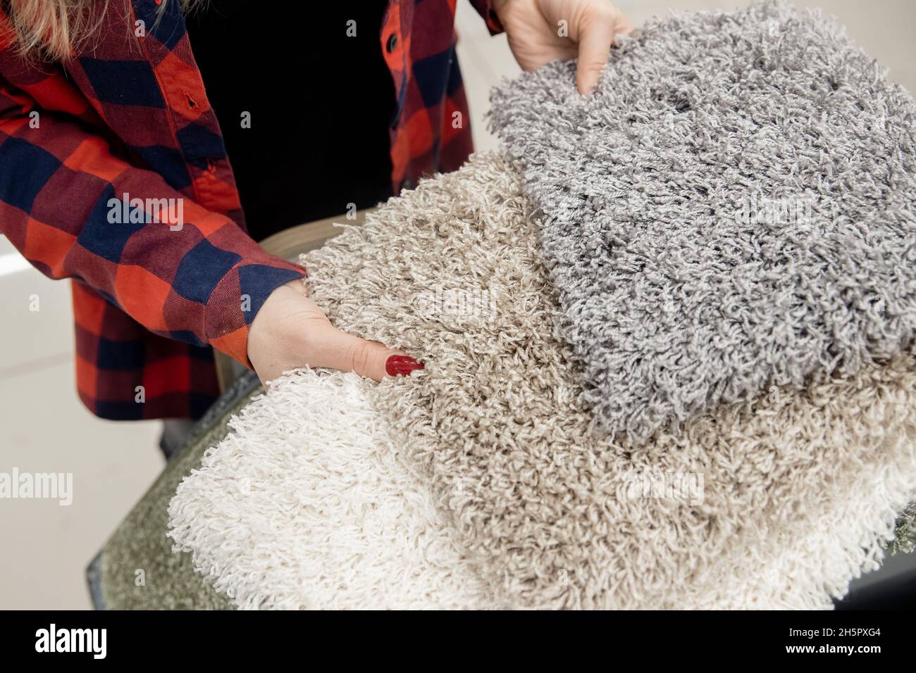 Closeup Designer shows examples of carpet rugs in textile store Stock ...