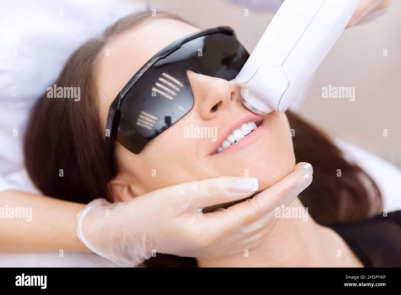 Master carries out removal moustache of unwanted hair laser on face