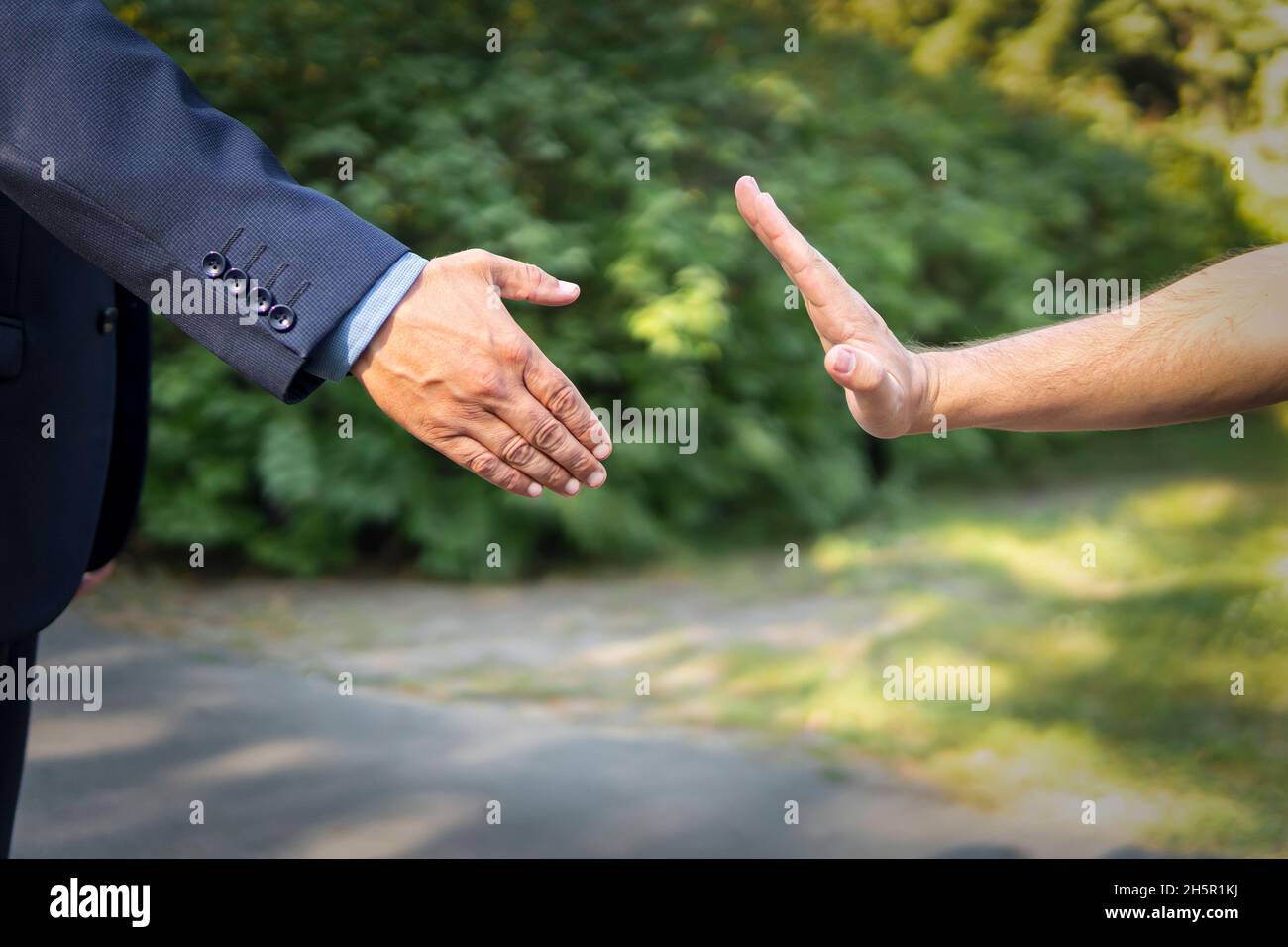man refusing hand shake with his friend to protect herself from coronavirus in public areas. Prevention of fight against pandemic. Non-contact greetin Stock Photo