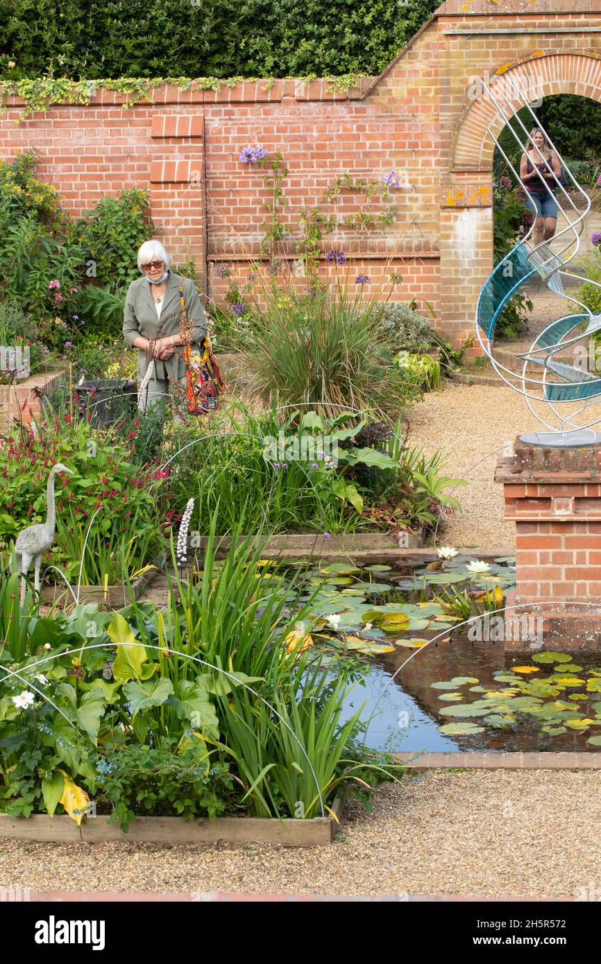 East Ruston Old Vicarage Gardens. Decorative, imaginative, modern sculpture, lily pond, aquatic, terrestrial, living plants, backdrop of considered br Stock Photo