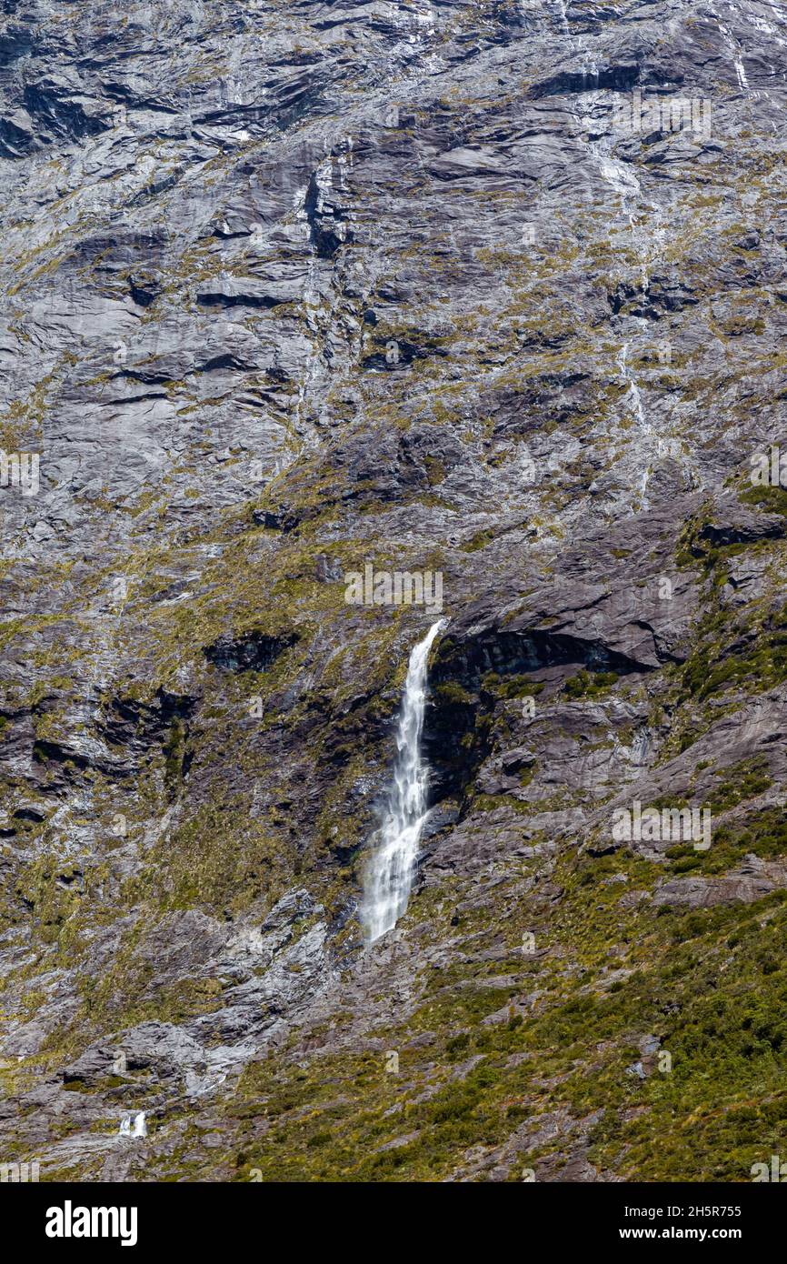 A small stream of water from the sheer cliffs on the way to Fiordland. South Island, New Zealand Stock Photo