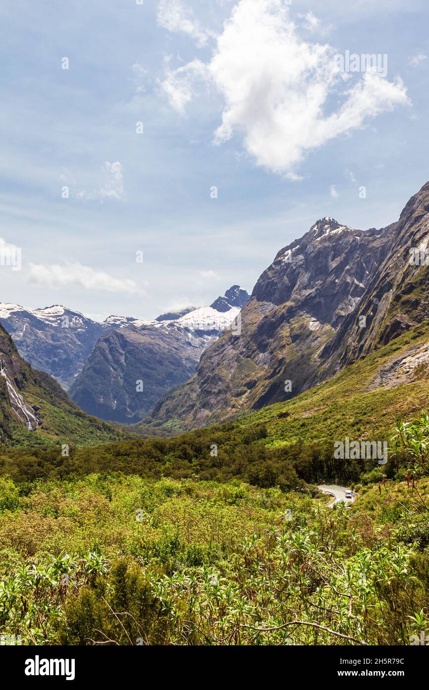 A green valley and snow-capped mountain peaks on the way to Fiordland. South Island, New Zealand Stock Photo