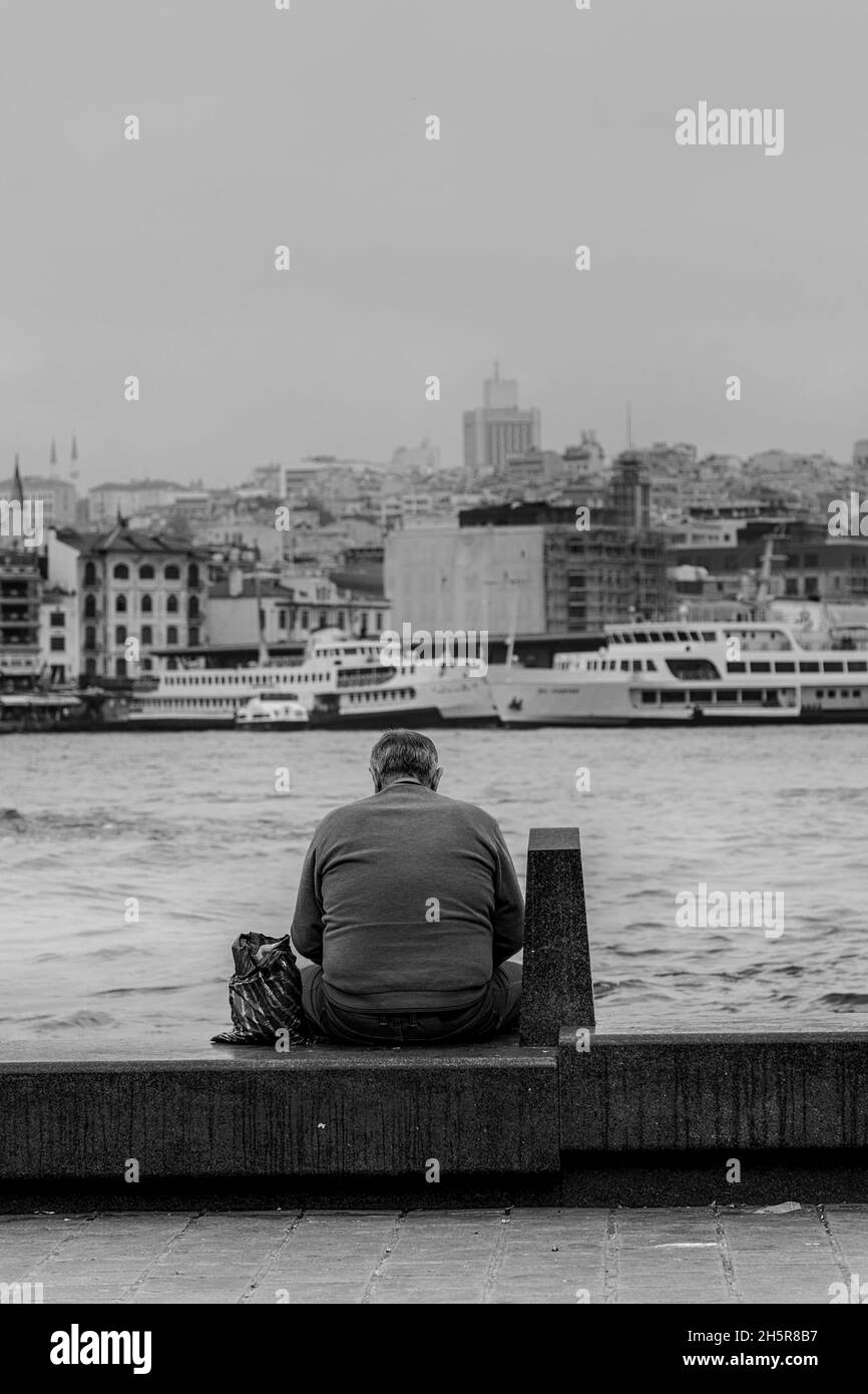 Man sitting on bench by the sea in Istanbul.Black and white image Stock Photo