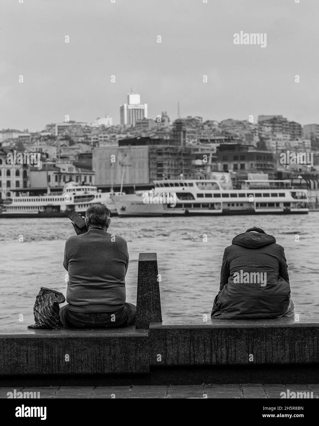 Man sitting on bench by the sea in Istanbul.Black and white image Stock Photo