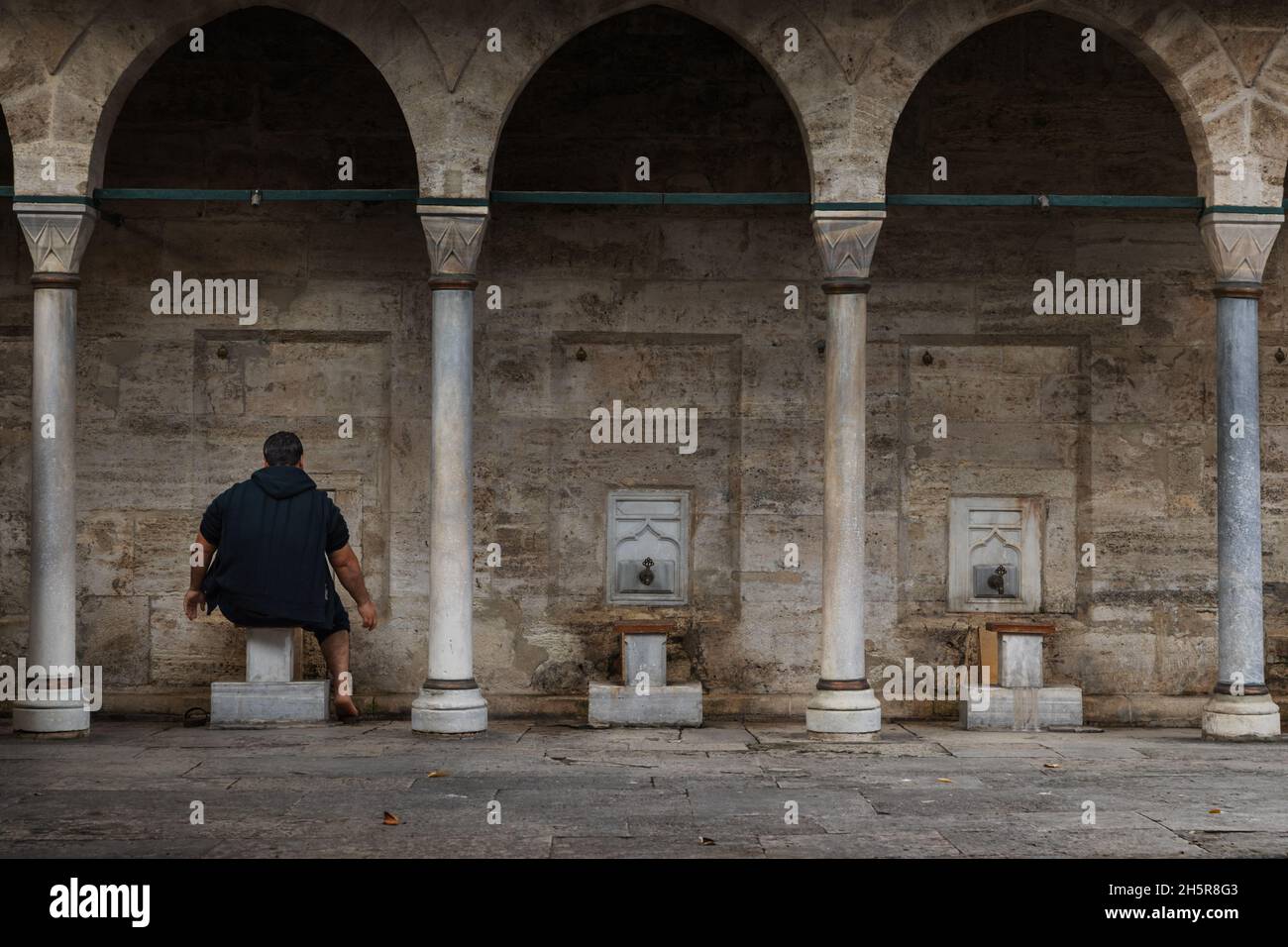 Unidentified man does ablution in the courtyard of a mosque in Istanbul Stock Photo
