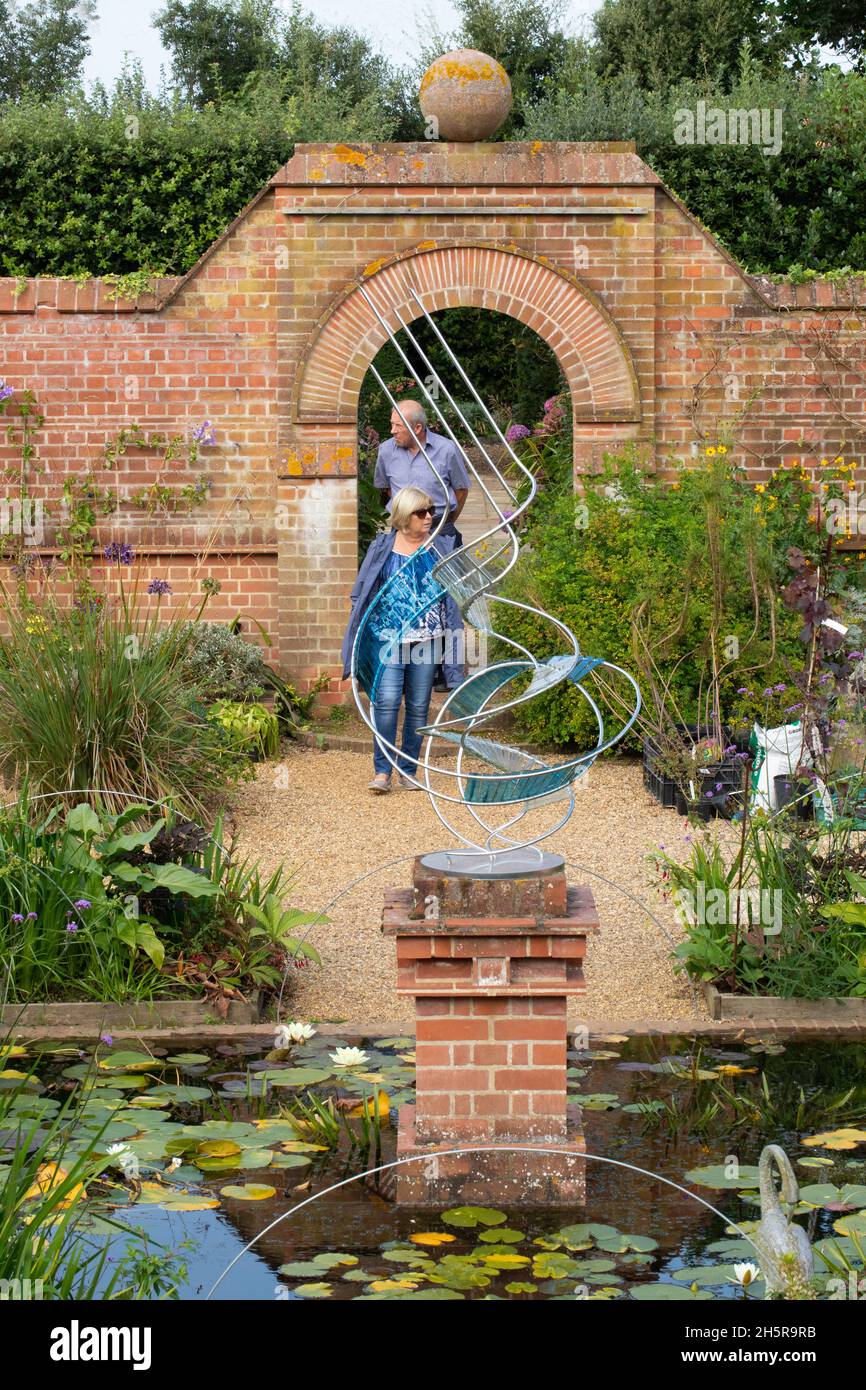 East Ruston Old Vicarage Gardens. Decorative, imaginative, modern sculpture, lily pond, aquatic, terrestrial, living plants, backdrop of considered br Stock Photo
