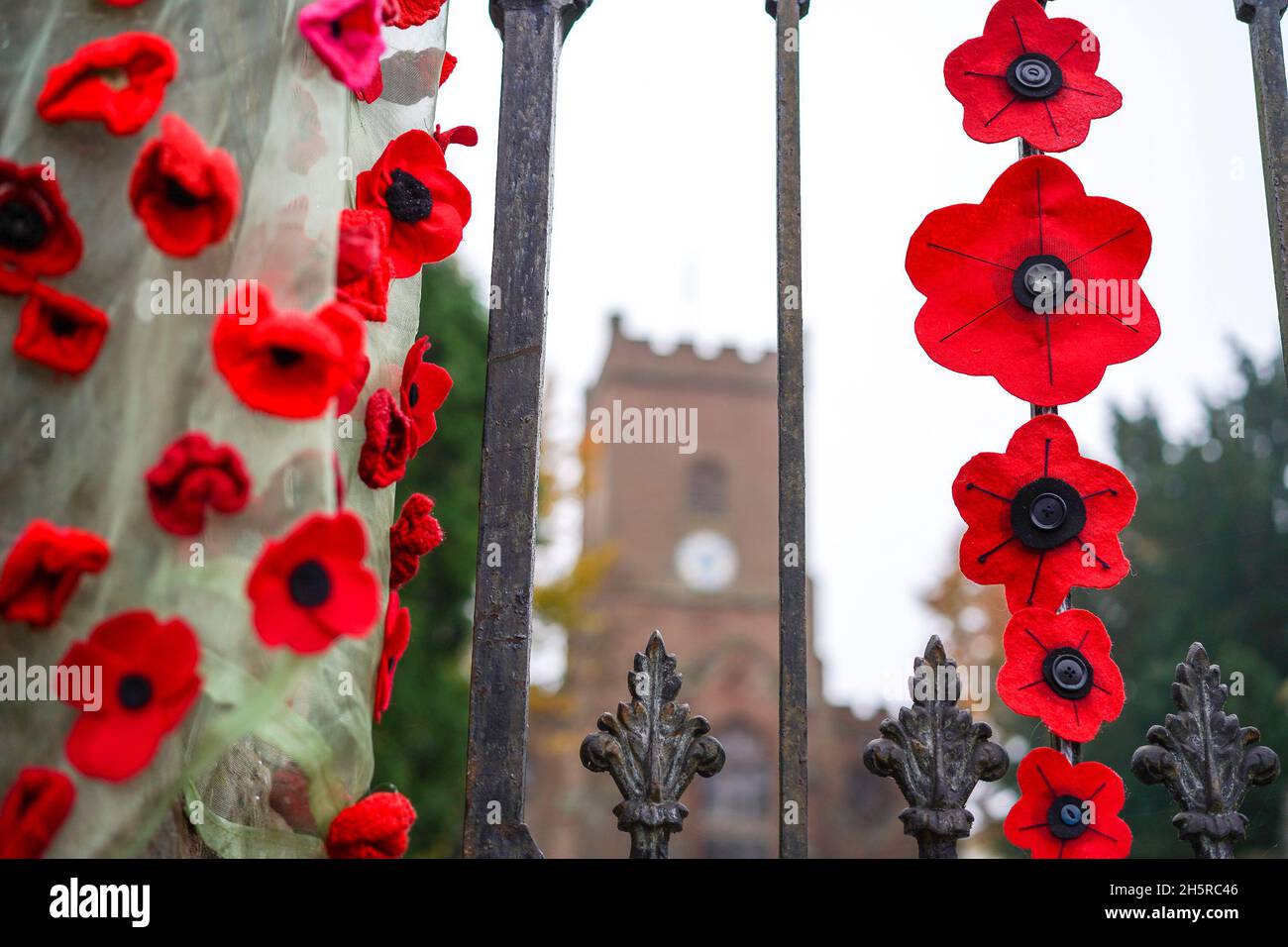 Hartlebury, UK. 11th November, 2021. UK weather: it's a grey wet day on armistice day 2021 but this church is brightened by the handemade poppies donated by the local people in a show of respect for our heroes. Credit Lee Hudson/Alamy Live News Stock Photo