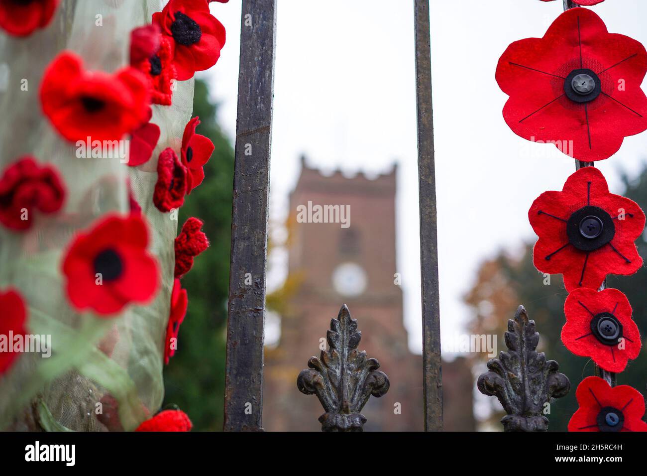 Hartlebury, UK. 11th November, 2021. UK weather: it's a grey wet day on armistice day 2021 but this church is brightened by the handemade poppies donated by the local people in a show of respect for our heroes. Credit Lee Hudson/Alamy Live News Stock Photo