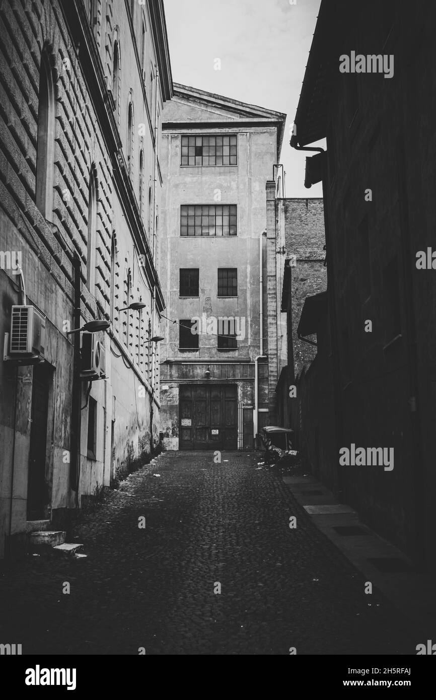 Grayscale shot of a narrow street between old buildings Stock Photo - Alamy