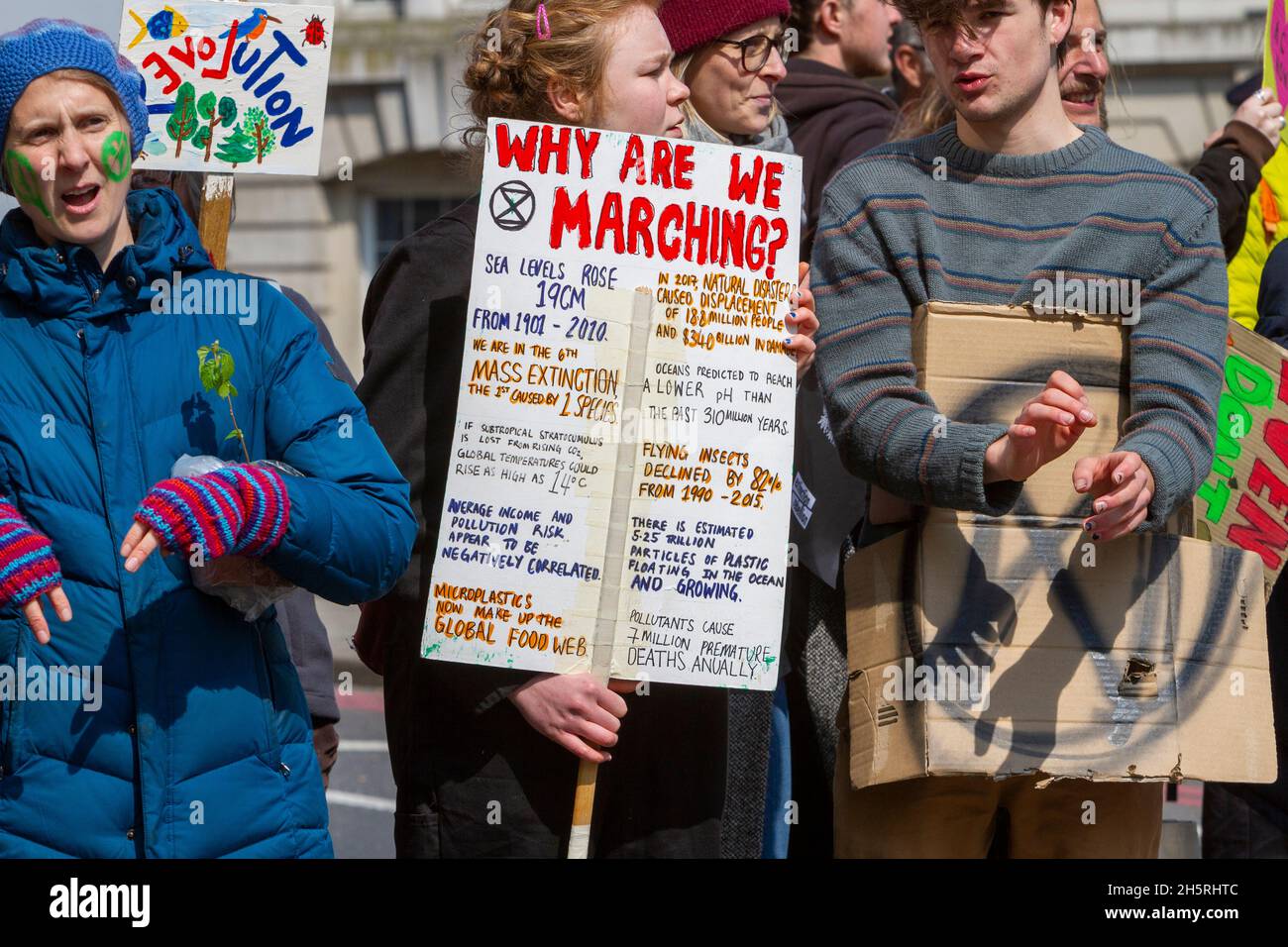 Street photograph of a group of climate change protestors close up holding homemade signs and placards. Stock Photo