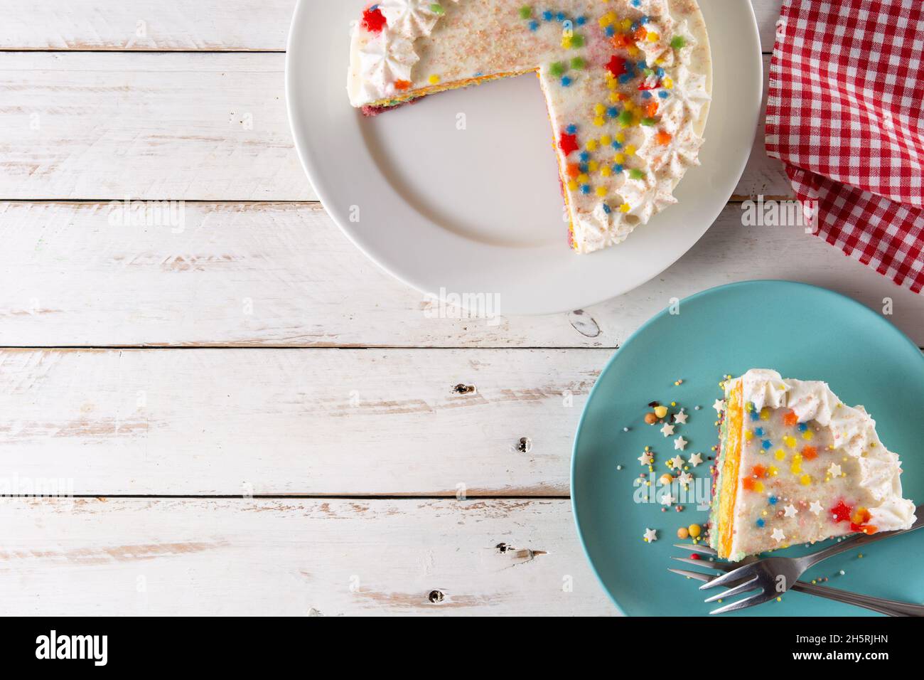 Rainbow layer cake on white wooden table Stock Photo