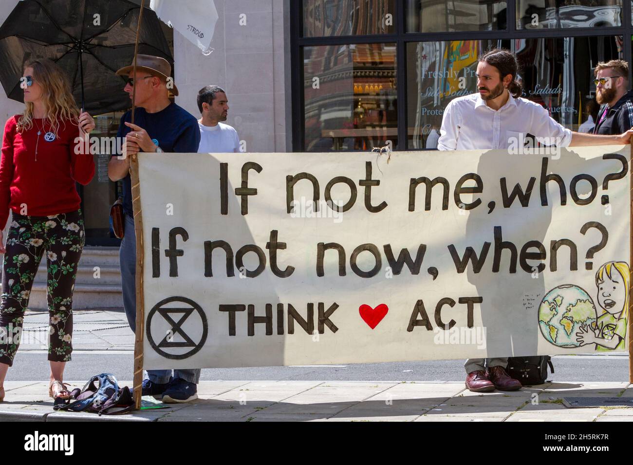 A group of people with banner in climate and environmental demonstration.  Street photography of activists in Extinction Rebellion protest. Stock Photo