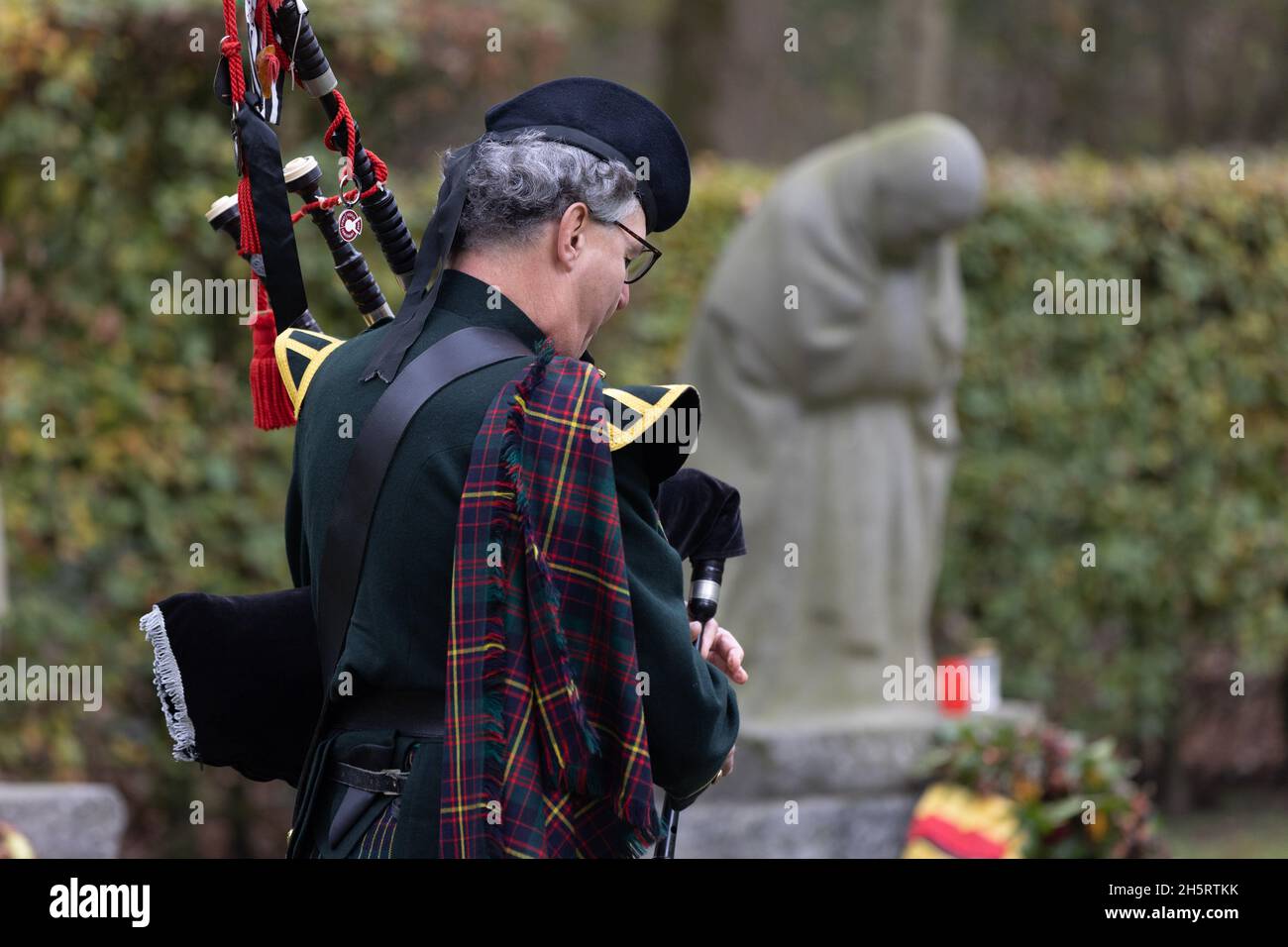 Vladlso, Belgium. 11th Nov, 2021. A bagpiper plays in remembrance of the fallen at the grave of Peter Kollwitz, near the memorial The Grieving Parents at German War Cemetery Vladslo in Flanders. Credit: Juergen Schwarz/Alamy Live News Stock Photo