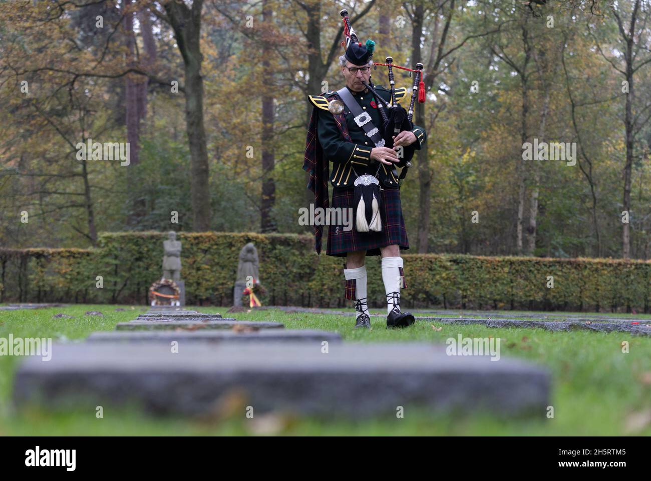 Vladlso, Belgium. 11th Nov, 2021. A bagpiper plays in remembrance of the fallen at the grave of Peter Kollwitz, near the memorial The Grieving Parents at German War Cemetery Vladslo in Flanders. Credit: Juergen Schwarz/Alamy Live News Stock Photo