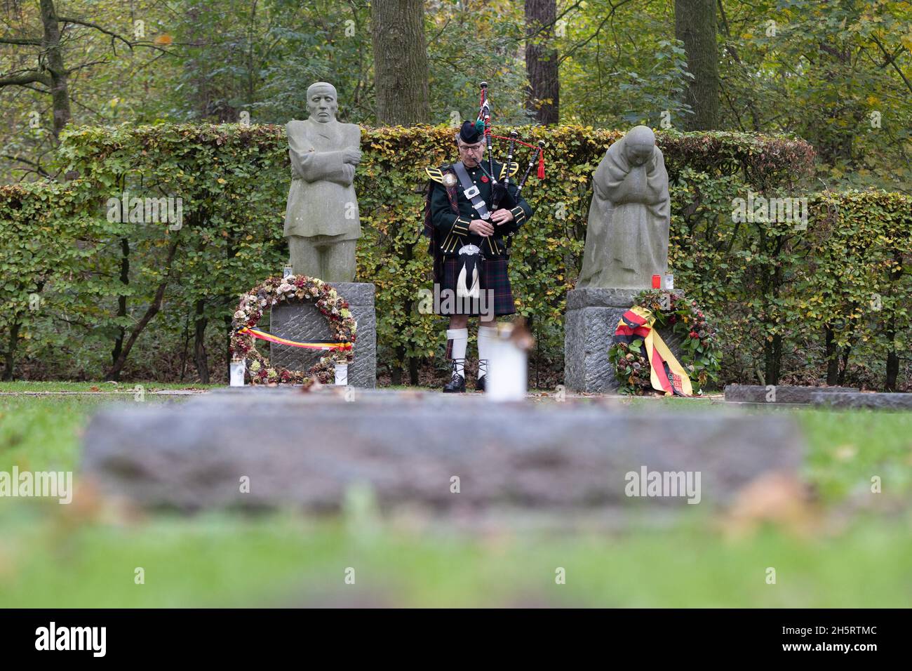 Vladlso, Belgium. 11th Nov, 2021. A bagpiper plays in remembrance of the fallen at the grave of Peter Kollwitz, near the memorial The Grieving Parents at German War Cemetery Vladslo in Flanders. Credit: Juergen Schwarz/Alamy Live News Stock Photo