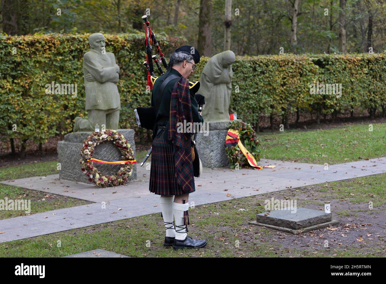 Vladlso, Belgium. 11th Nov, 2021. A bagpiper plays in remembrance of the fallen at the grave of Peter Kollwitz, near the memorial The Grieving Parents at German War Cemetery Vladslo in Flanders. Credit: Juergen Schwarz/Alamy Live News Stock Photo