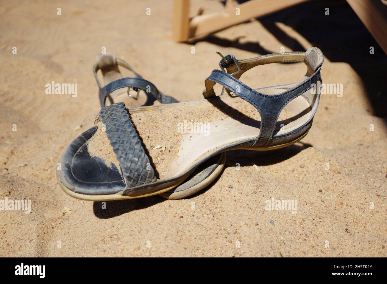 Pair of sandals on sand on a sunny day Stock Photo
