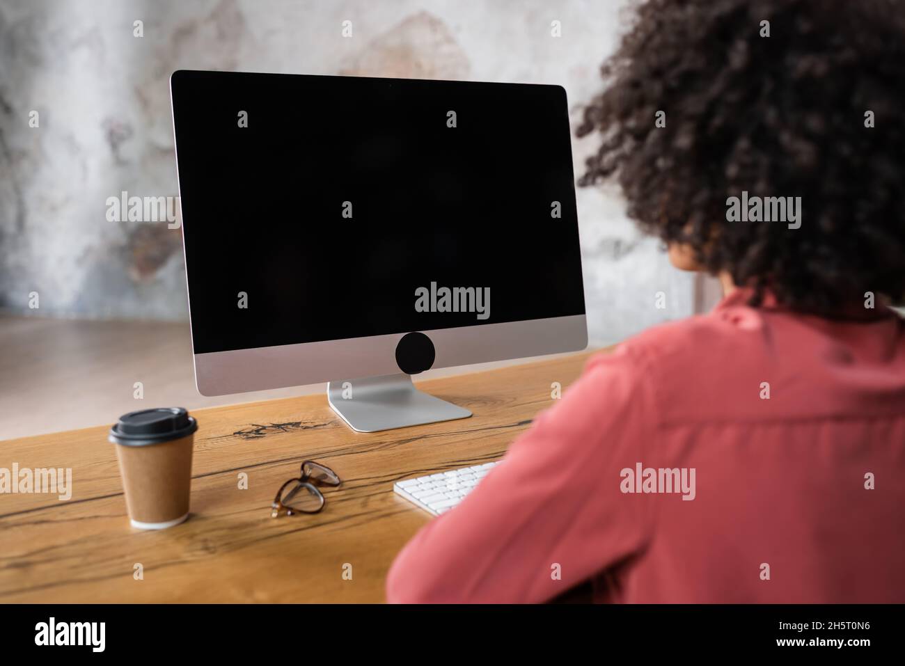 back view of blurred african american woman near computer monitor ...
