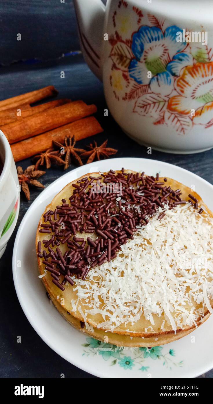Vertical shot of a martabak with a chocolate topping and grated cheese