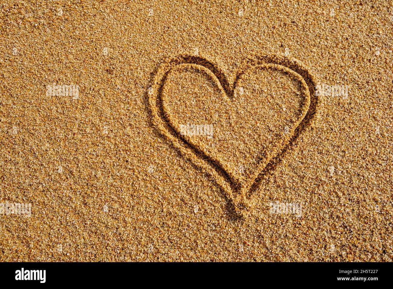 Heart sign written on sand in evening sunlight Stock Photo