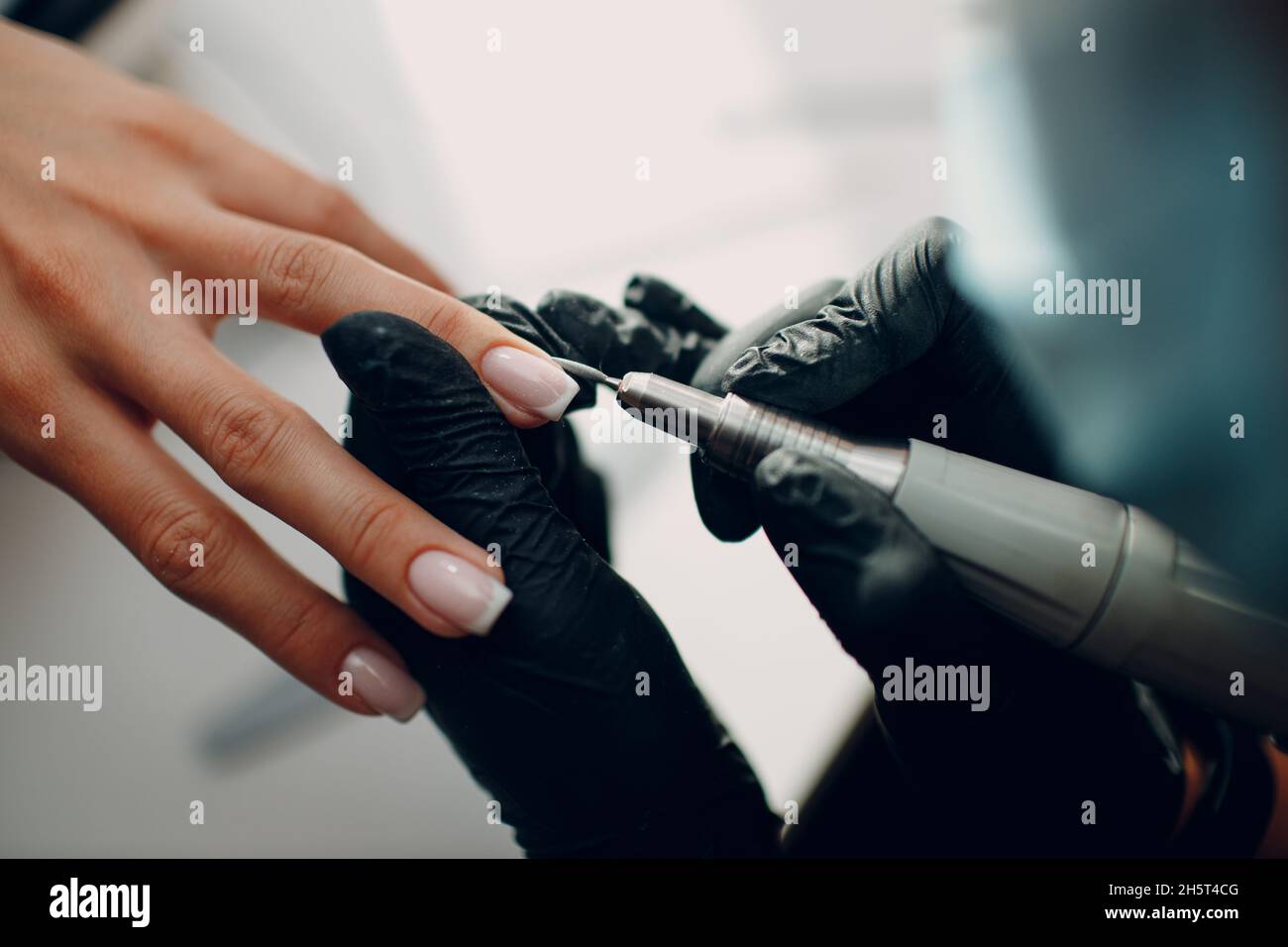 Manicure process female hands finger nails polish. Fingernail polishing machine Stock Photo