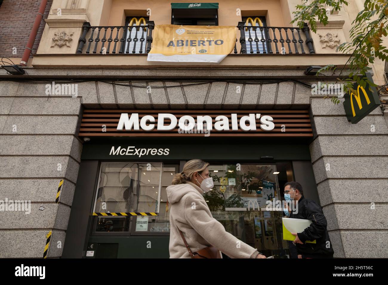 Madrid, Spain Nov 25, 2020 Several people walk in front of the fast food restaurant, McDonald