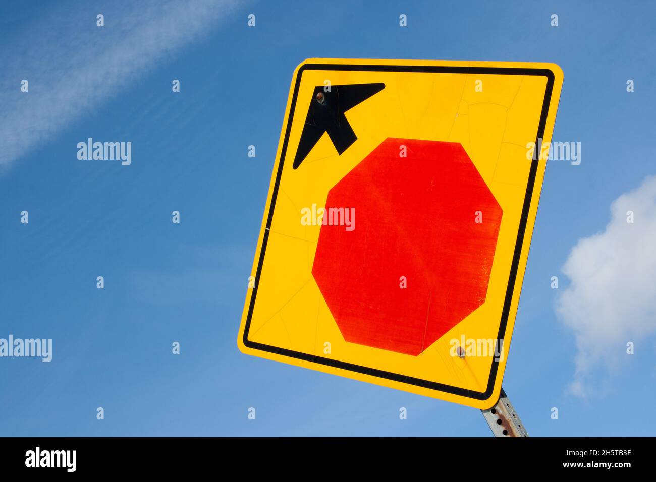 Closeup of the stop ahead sign against the blue sky. Stock Photo