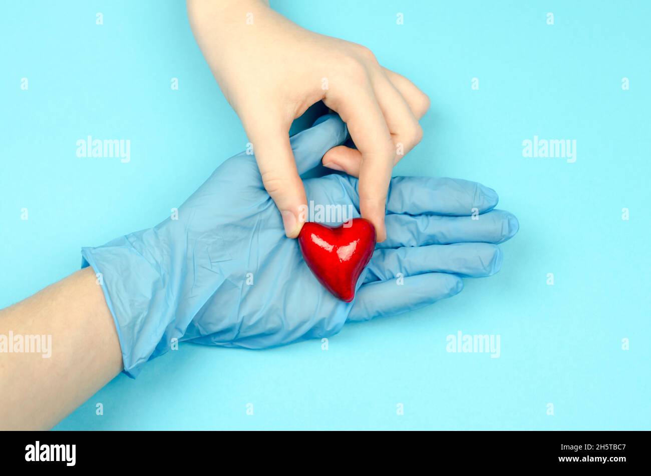The child's hand puts the heart in the doctor's hand Stock Photo - Alamy