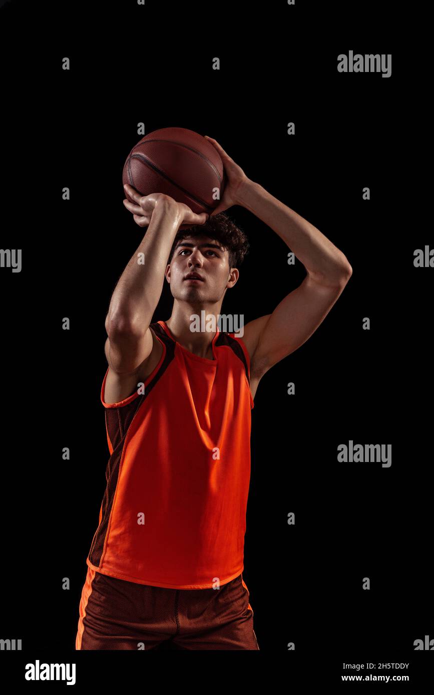 Studio shot of young man, basketball player doing set shot isolated on