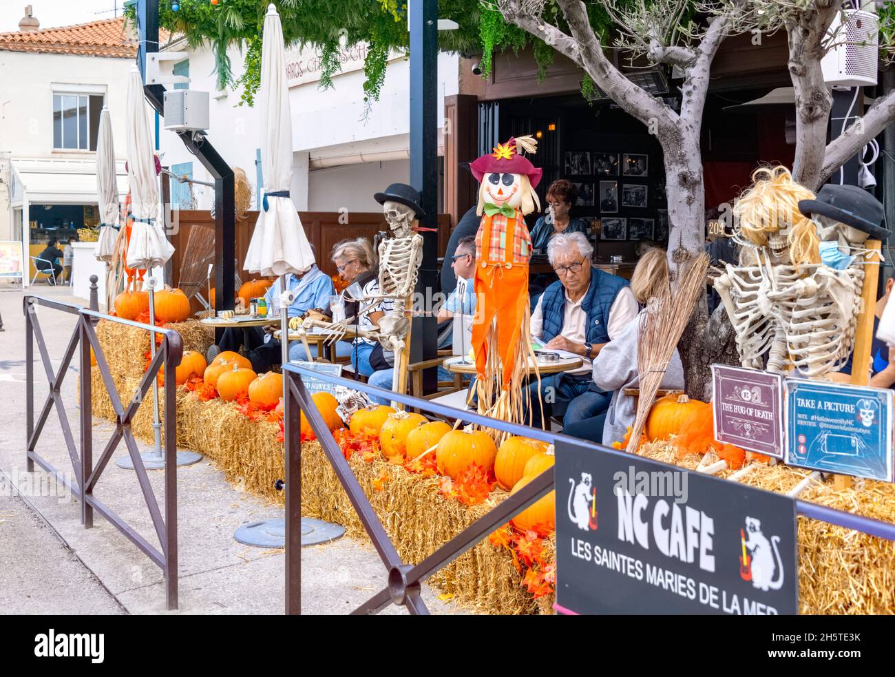 People sitting at  NC Cafe, Saintes Maries de la Mer, Camargue, France surrounded by halloween decorations Stock Photo
