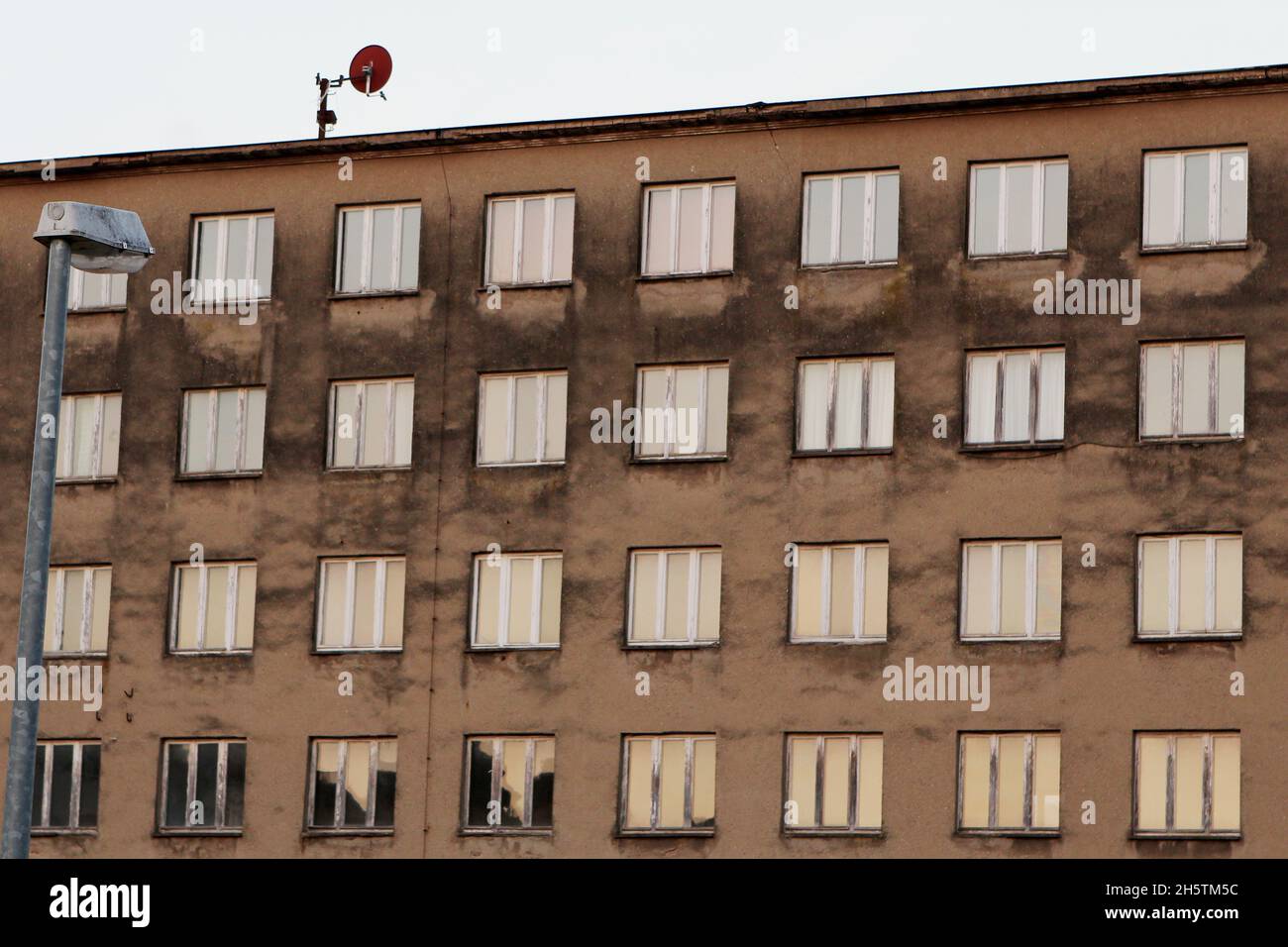 Foto von der Landseite eines alten Blocks des Prora-Komplexes 'Koloss von Prora' vor der Rekonstruktion, mit Laterne und Antenne. Rügen, Deutschland. Stock Photo