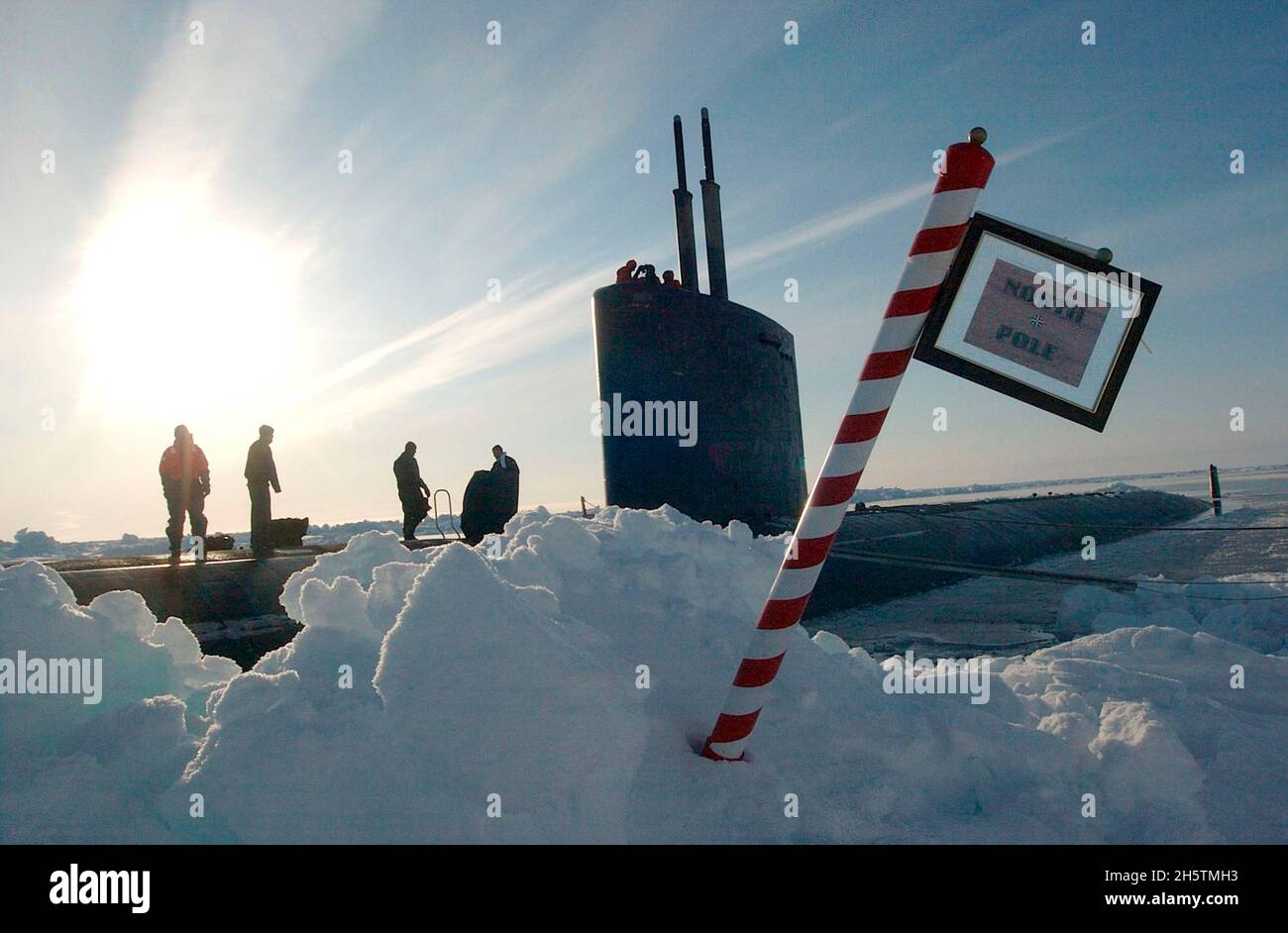 Crews with the U.S. Navy Los Angeles-class attack submarine USS Hampton and British Royal Navy Trafalgar class attack submarine HMS Tireless meets next to a sign indicating the North Pole after surfacing together May 3, 2004 at the North Pole. The Tireless and the Hampton were taking part in joint exercises ICEX 04, beneath the polar ice cap. Stock Photo