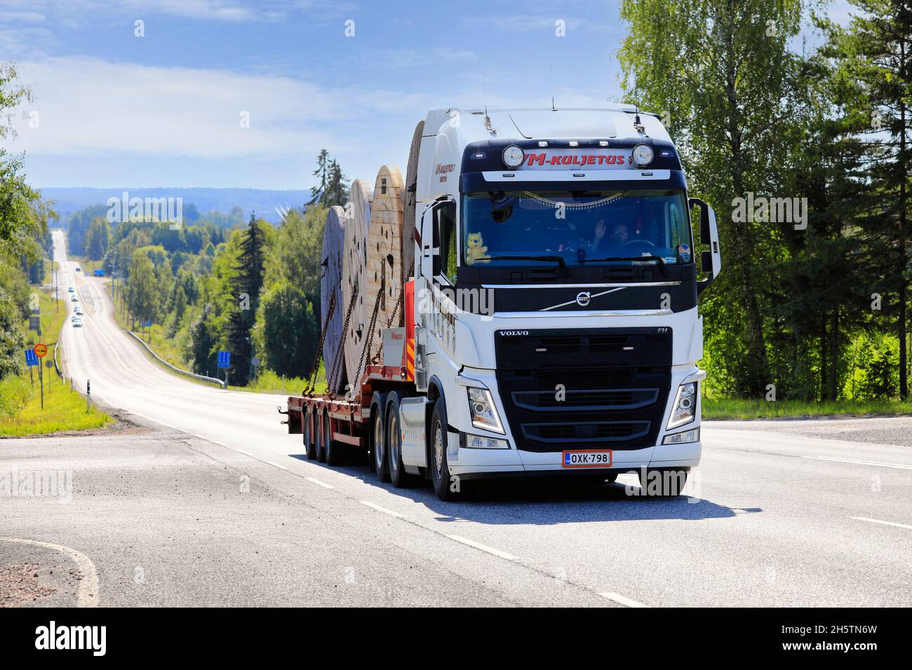 White Volvo FH truck of VM-Kuljetus Oy transports power cable drums on semi trailer. Ikaalinen, Finland. August 12, 2021. Stock Photo
