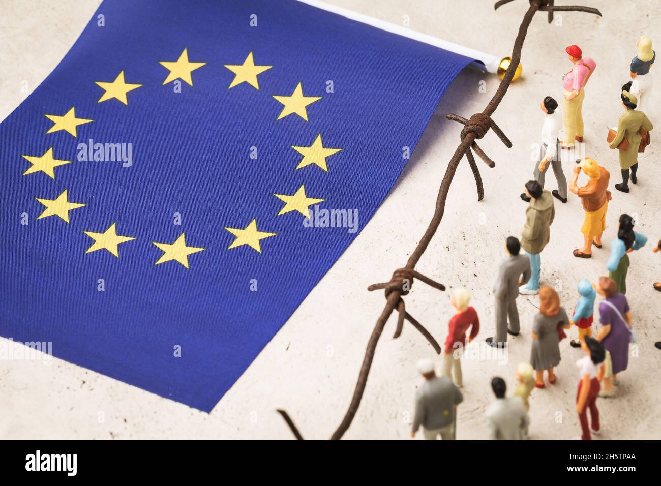 Plastic toy men, barbed wire and eu flag, migrants crossing the border concept Stock Photo