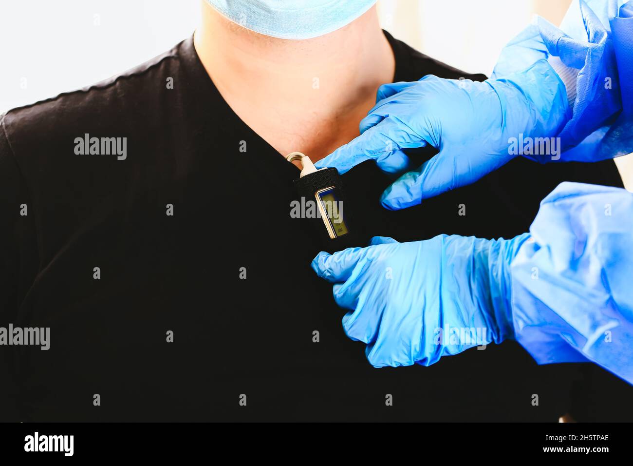 doctor attaches a holter to the man's chest. Daily monitoring of the heart. Cardiology. Stock Photo