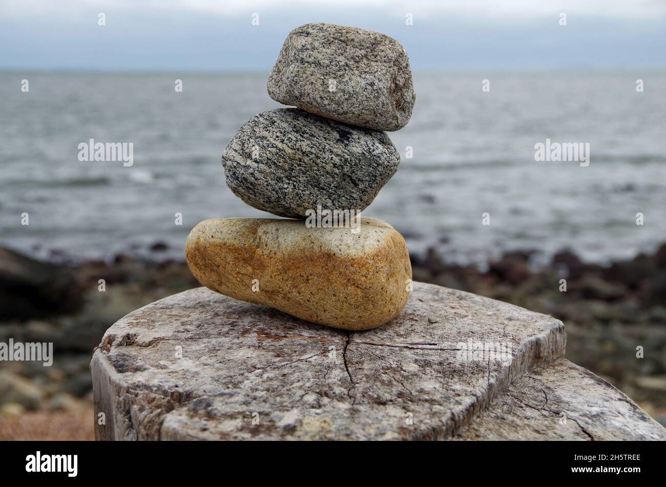 Three stacked stones with sea shore background. Concept of stability. Stock Photo