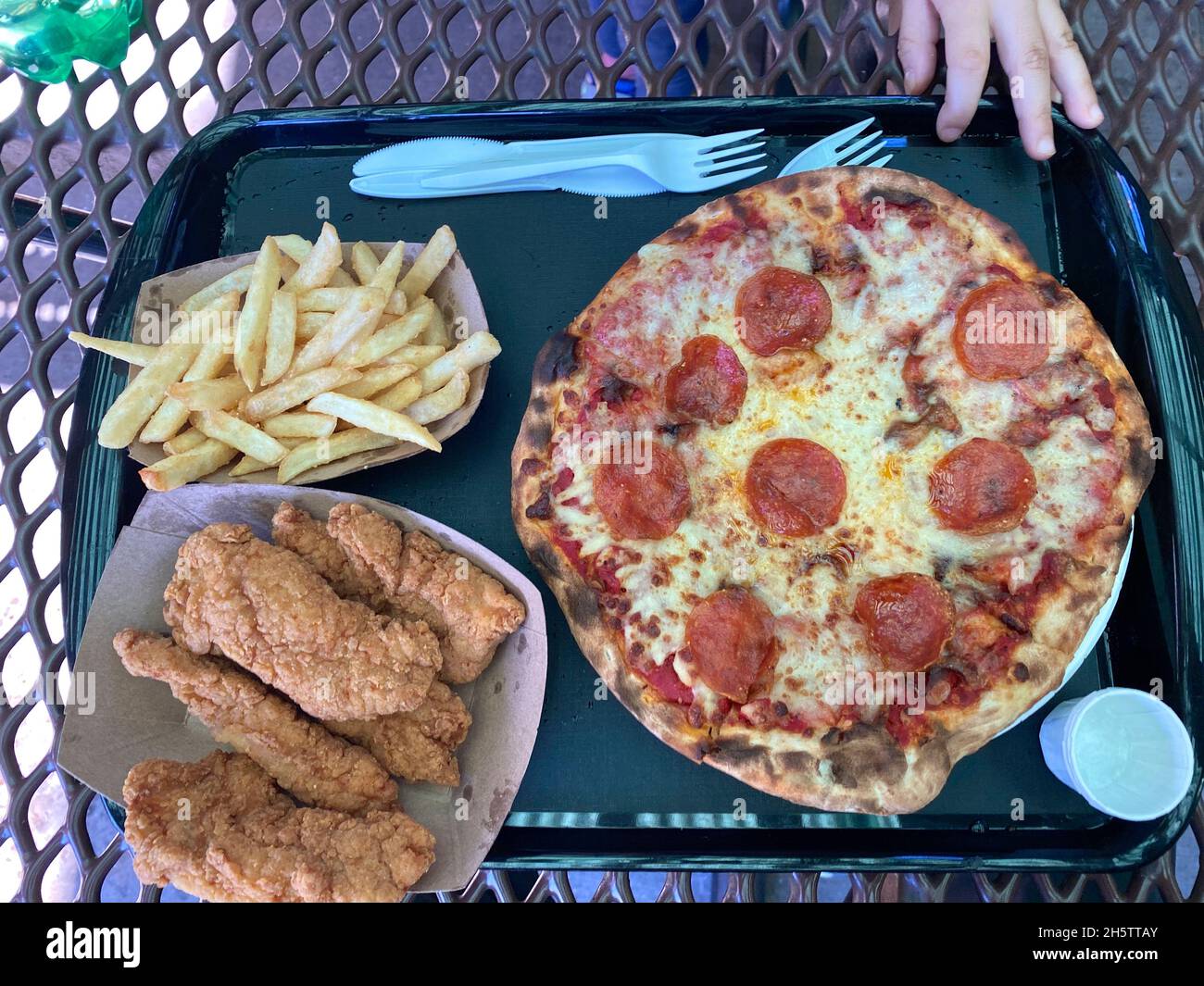 Meal with pepperoni pizza with cheese, chicken tenders and french fries Stock Photo