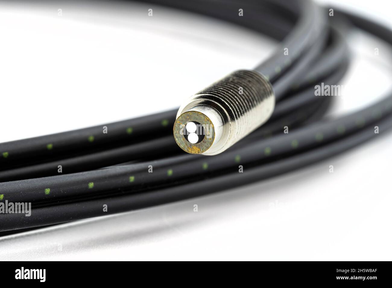 Macro photo of a fiber optic cable with two inserts, isolated on a white background, terminated with a thread. Stock Photo