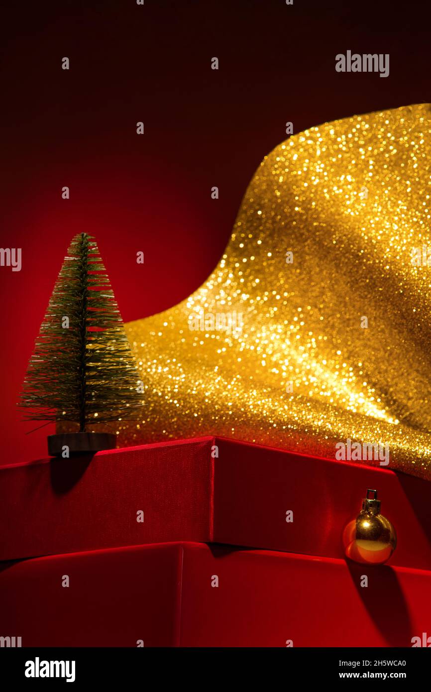 Majestic red podium with gift boxes and gold Christmas decor and tree ...