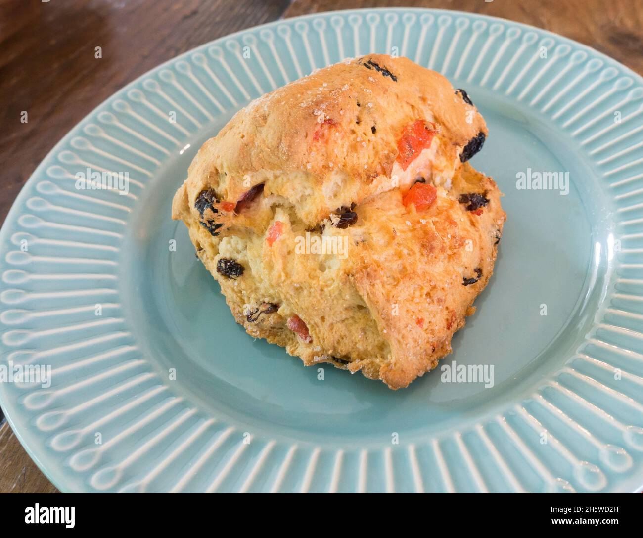 A fruit scone with cherries on a plate. Stock Photo