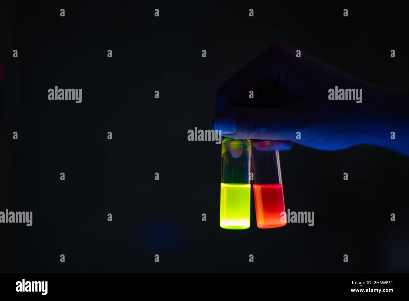 A woman researcher holding chemistry photochemical reaction glass vials