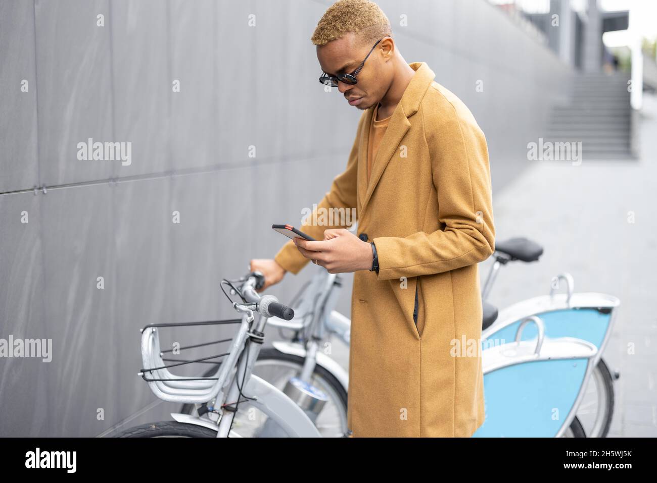 Man using smartphone app for bike rent Stock Photo