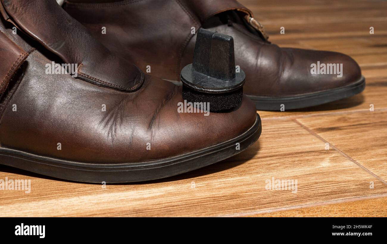 Men's shoe shine. A man applies cream to leather shoes Stock Photo