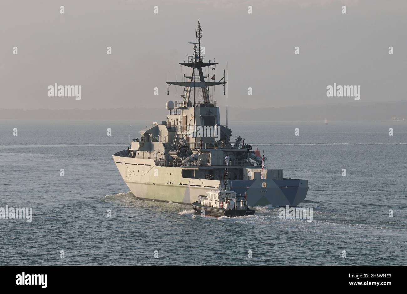 The Royal Navy patrol vessel HMS SEVERN heads into The Solent closely followed by an Admiralty pilot launch Stock Photo