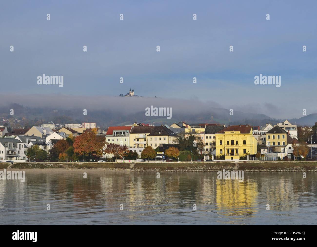 Autumn day in Linz, Austria with beautiful reflection and Postlingberg in the fog. Stock Photo