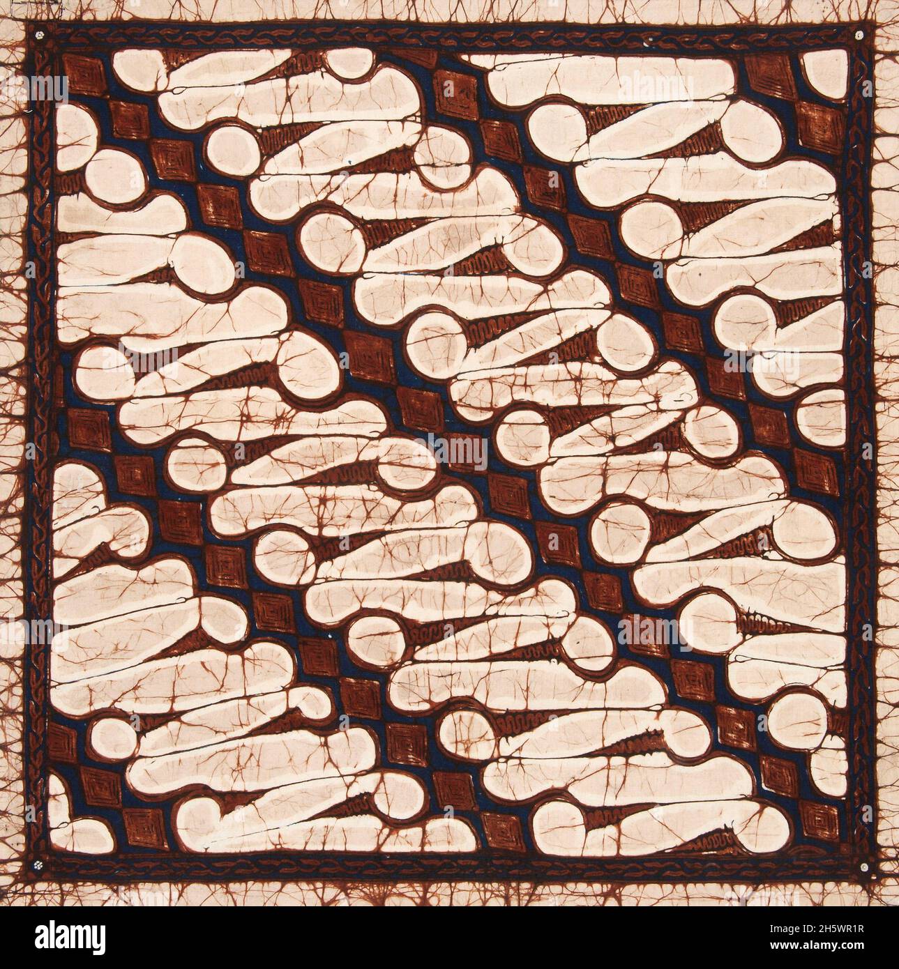 Batik pattern: Parang rusak barong This patched pattern is a very large and coarse Parang rusak pattern, the destroyed machete pattern. The name of this type of Parang pattern is Parang rusak barong, the werewolf Parang rusak. The border consists of brown leaves on a blue background. Stock Photo