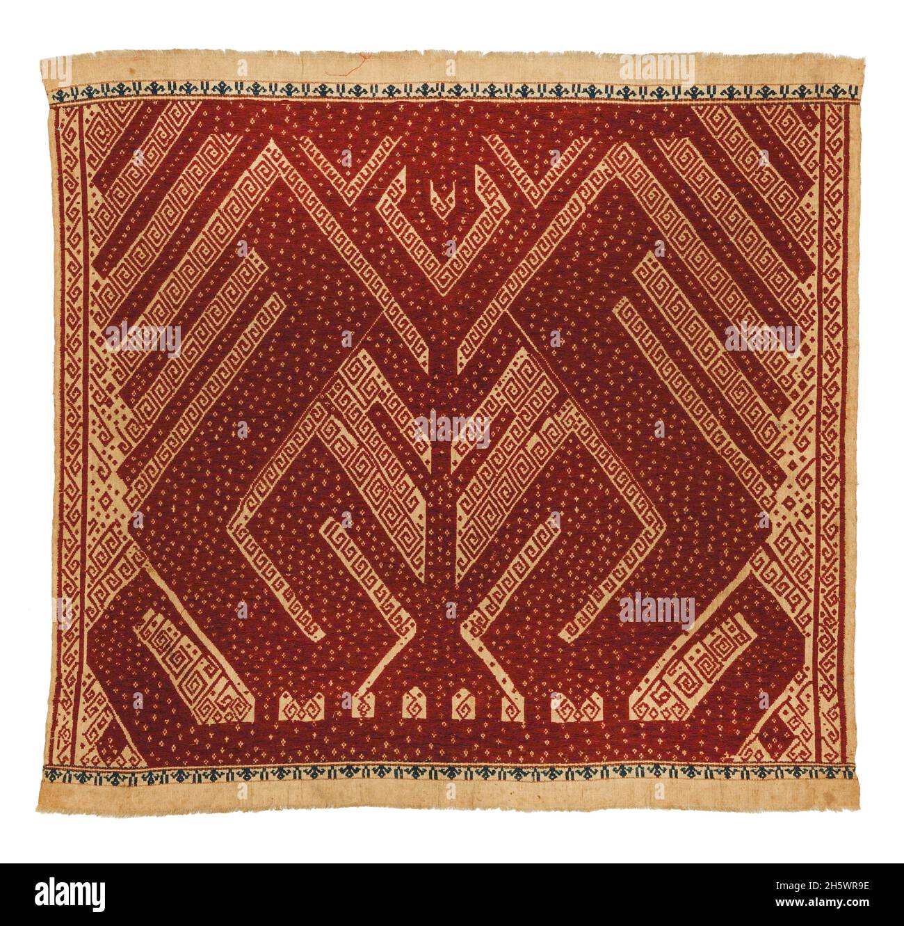 Ceremonial textile, C19th, Lampung, Sumatra. Tampan were used for rites of passage ceremonies, as the focal point for ritual meals, the seat for elders overseeing traditional law, and tied to newly-built houses. Those woven in blue depict the secular realm, those in red the sacred. Examples from the mountainous interior show stylised natural or domestic subjects and geometric designs, while those from the coast (tampan pasisir) display richly detailed scenes of ships and other motifs. The ship, the main motif, symbolises movement, appropriate to the rites of passage rituals. Stock Photo